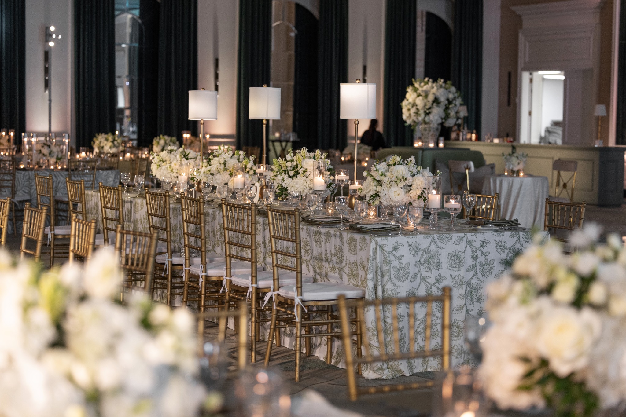 Elegant candlelit wedding reception with floral arrangements and warm architectural lighting